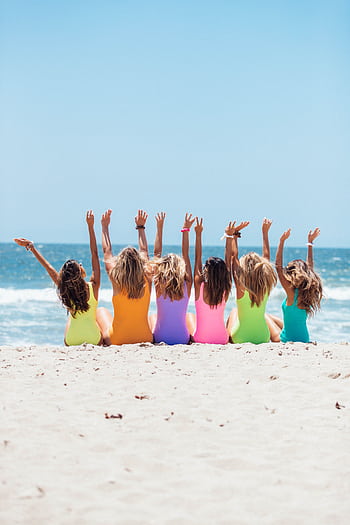 A joyful group of women with hands raised enjoying a sunny day at Santa Monica Beach. HD phone wallpaper