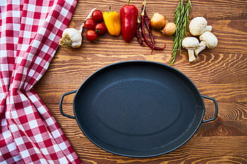 Empty cast iron pan with fresh ingredients on a wooden table. HD wallpaper