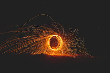 Captivating steel wool graphy showcasing vibrant sparks and dynamic energy at night. HD wallpaper