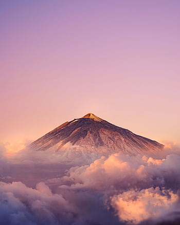 Stunning view of Mount Teide at sunrise surrounded by vibrant clouds and serene sky. HD phone wallpaper
