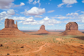 A breathtaking view of Monument Valley's buttes under a clear blue sky, perfect for travel enthusiasts. HD wallpaper