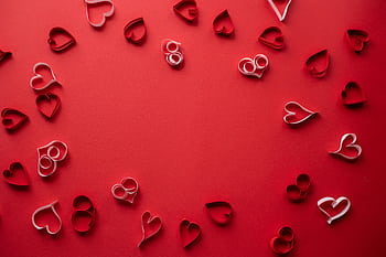 Beautiful red and white paper heart shapes on a vibrant red background, perfect for Valentine's Day designs. HD wallpaper