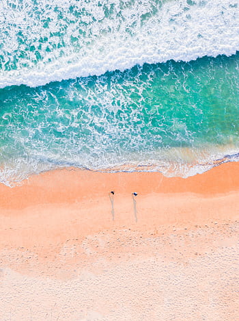 Stunning aerial shot of a sandy beach with turquoise ocean waves, capturing the natural beauty of the coastline. HD phone wallpaper