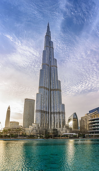 Majestic Burj Khalifa against a bright blue sky reflecting in water, Dubai. HD phone wallpaper