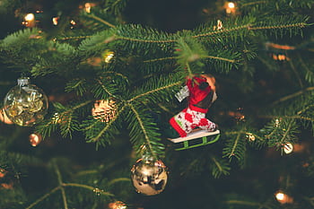 Close-up of a decorated Christmas tree with ornaments and warm lights. HD wallpaper