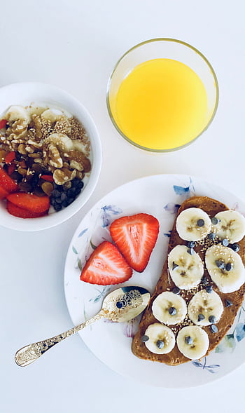 Nutritious breakfast with banana toast, fruit bowl, and orange juice, perfect for a healthy start. HD phone wallpaper