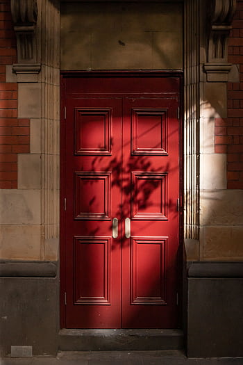 A classic red door in Melbourne with striking shadows and detailed woodwork. HD phone wallpaper