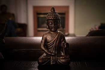 Close-up of a Buddha statue emphasizing tranquility and mindfulness within an indoor setting. HD wallpaper
