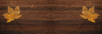 Two autumn maple leaves on a rustic wooden background, ideal for seasonal designs. HD wallpaper