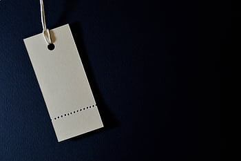 Elegant minimalist card with a string, ideal for labeling or pricing against a black background. HD wallpaper