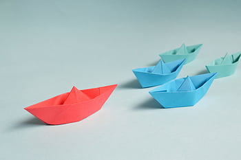 Colorful origami paper boats arranged to depict leadership and teamwork concepts. HD wallpaper