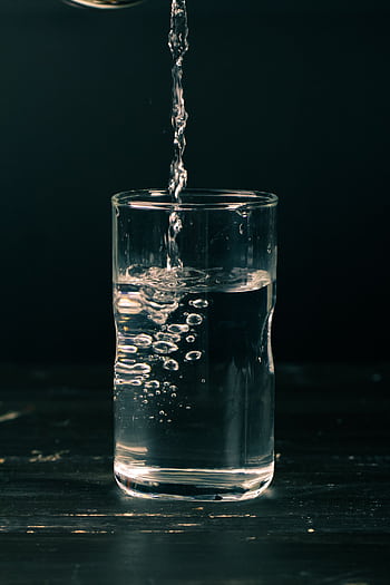 Clear water being poured into a glass with visible bubbles, dark background, refreshing feel. HD phone wallpaper