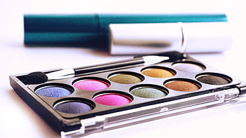 Close-up of colorful eyeshadow palette with brush, ideal for fashion and beauty themes. HD wallpaper