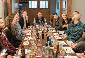 A joyful group of adults enjoying a meal and drinks at a restaurant, fostering communication and friendship. HD wallpaper