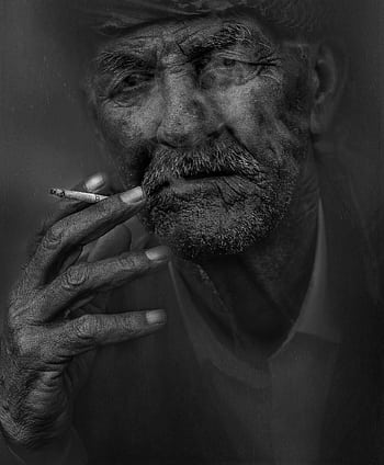A striking black and white portrait of an elderly man smoking, highlighting facial wrinkles. HD phone wallpaper