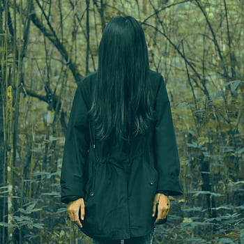 A spooky scene of a woman with hidden face in a dark forest, evoking mystery and horror. HD phone wallpaper