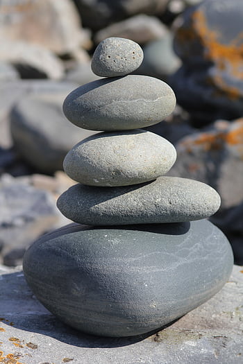 Stacked stones create a harmonious balance, exemplifying simplicity and tranquility in nature. HD phone wallpaper