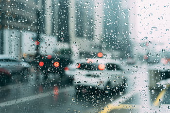 Blurred city traffic seen through a window with raindrops, a perfect rainy day scene. HD wallpaper