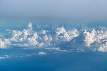 A captivating aerial view of fluffy white clouds against a serene blue sky, perfect for . HD wallpaper