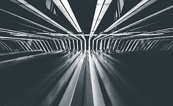 Abstract black and white capturing futuristic light streaks in a modern tunnel, creating a dynamic sense of motion. HD wallpaper