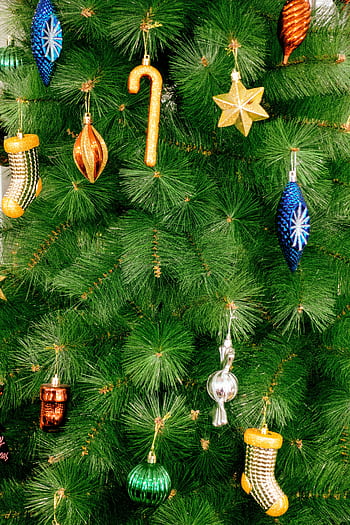Close-up of a festive Christmas tree adorned with colorful ornaments and decorations. HD phone wallpaper