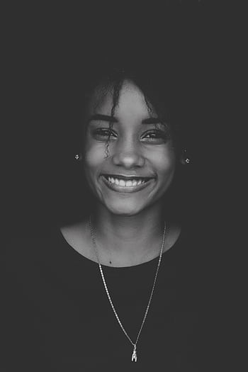 Black and white portrait of a smiling woman showcasing elegance and beauty. HD phone wallpaper