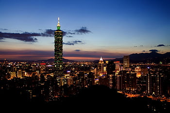 Stunning view of Taipei 101 and cityscape illuminated at twilight showcasing urban charm and vibrant lights. HD wallpaper