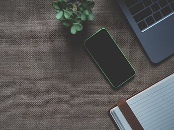 A stylish overhead view of a workspace with a laptop, smart, and plant. HD wallpaper