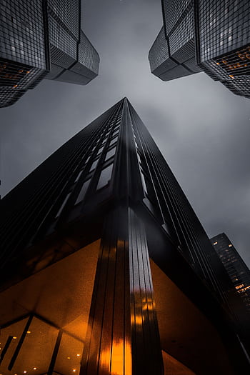 A low angle view of skyscrapers reaching into a moody night sky, showcasing modern architecture. HD phone wallpaper