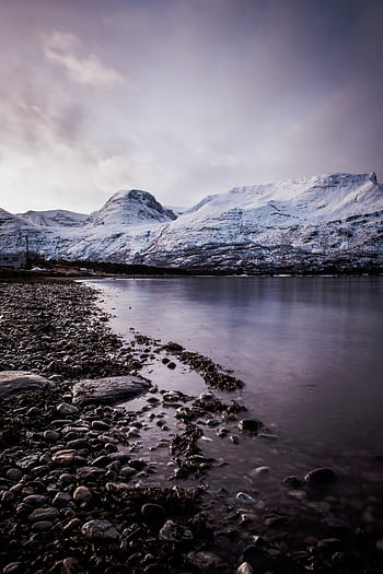 Breathtaking view of snow-capped mountains and calm water in Skibotn, Norway at sunset. HD phone wallpaper