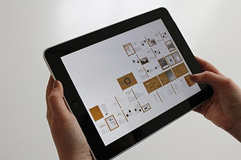 Close-up of hands using a tablet, displaying a digital interface. HD wallpaper