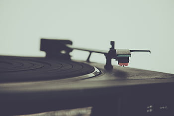 Detailed view of a vintage turntable, highlighting the stylus and platter for retro audio enthusiasts. HD wallpaper