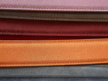 Close-up of colorful leather belts showcasing detailed stitching. HD wallpaper