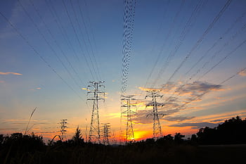 Silhouette of power lines against a dramatic sunset sky in a rural landscape. HD wallpaper