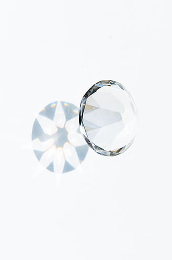 A detailed of a faceted diamond showcasing a prism effect on a clean white background. HD phone wallpaper