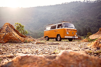 Classic VW van parked on rocky terrain with mountains in Alegría, El Salvador. HD wallpaper