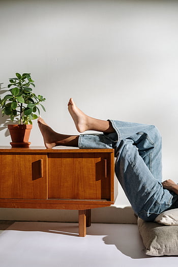 Casual lifestyle scene with bare feet and denim in a cozy interior. HD phone wallpaper