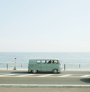 A classic Volkswagen van driving on a seaside road in Fujisawa, Japan, capturing a nostalgic coastal vibe. HD phone wallpaper