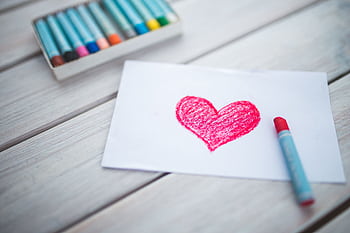 A vibrant red heart drawn with crayons on white paper, perfect for Valentine's Day themes. HD wallpaper