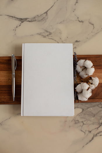 Top view of a minimalist white journal with cotton on a wooden board. Ideal for creative projects. HD phone wallpaper