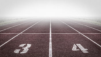 A foggy track field with visible lane numbers and white lines. HD wallpaper