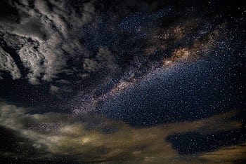 A breathtaking capturing the Milky Way galaxy with stars and clouds in a dark, starry sky. HD wallpaper