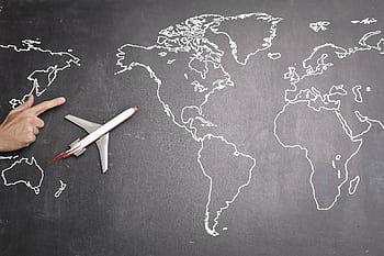 Airplane toy placed on a chalk drawn world map indicating travel and exploration. HD wallpaper