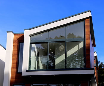 Contemporary house in Poole, UK featuring a sleek design with large glass windows and wood paneling. HD wallpaper