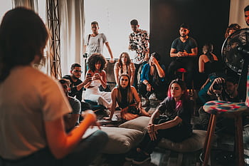 A diverse group gathered indoors in São Paulo for an engaging discussion session. HD wallpaper