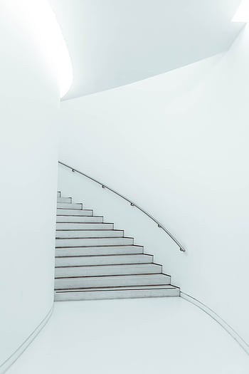A sleek, minimalist staircase with a curved metal railing in a bright modern interior setting. HD phone wallpaper