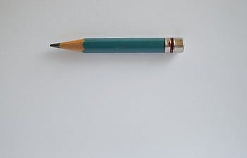 Minimalist of a sharpened green pencil on a plain white background. HD wallpaper