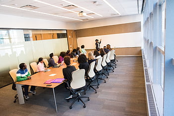 A diverse group actively collaborating in a bright, modern conference room setting. HD wallpaper