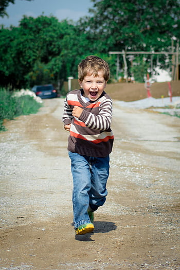 A young boy joyfully runs down a path, showcasing playful energy in a Czech outdoor setting. HD phone wallpaper