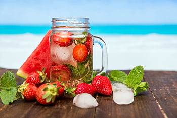 Chilled drink with strawberries, watermelon, and mint in a mason jar, perfect for summer refreshment. HD wallpaper